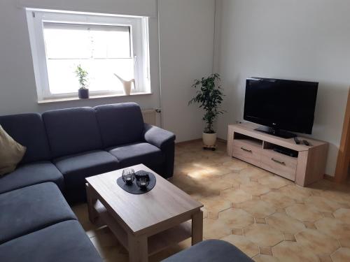 a living room with a couch and a tv at Ferienwohnung Kleeblatt in Alpen