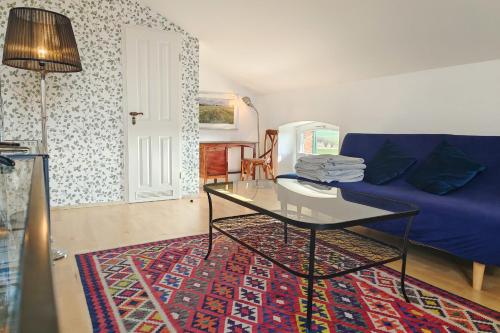 a living room with a blue couch and a table at FeWo Uckerseen, 4 Zimmer mit Bad ensuite und Panoramablick in Seehausen
