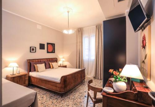 a hotel room with a bed and a tv at Musica Guest House in Alghero
