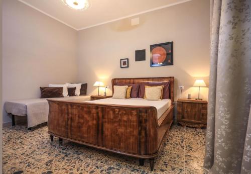 a bedroom with a large wooden bed and two lamps at Musica Guest House in Alghero
