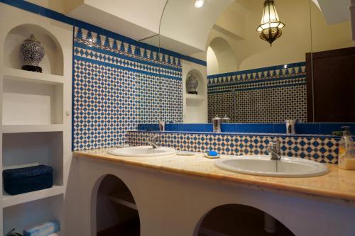 La salle de bains est pourvue de 2 lavabos ainsi que de carrelage bleu et blanc. dans l'établissement Apartamento Calypso, exclusivo, comodo, recien reformado, terraza con estupendas vistas y grill, todo cercano y la playa andando, à La Vila Joiosa