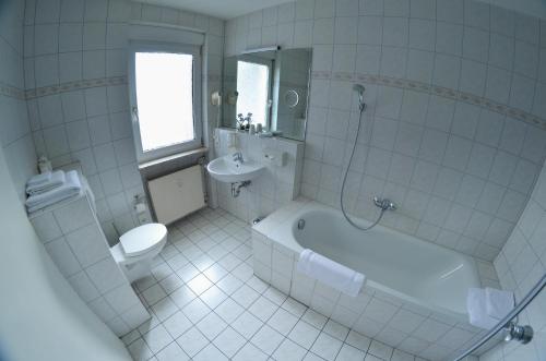 a bathroom with a tub and a toilet and a sink at Hotel Am Markt in Karlsruhe