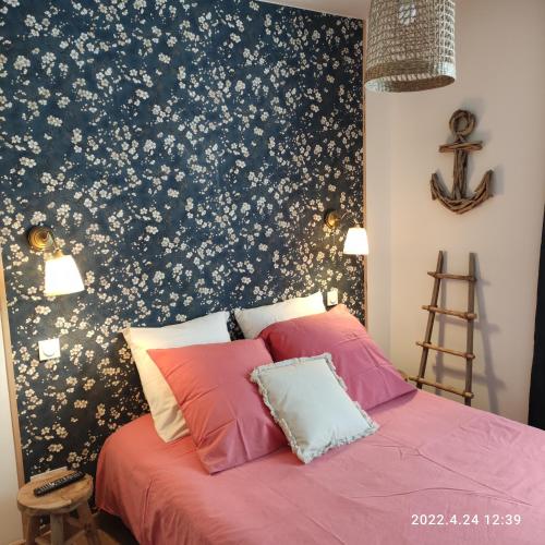 - une chambre avec un lit orné de motifs floraux dans l'établissement LES MOUETTES DU PORT, à Honfleur