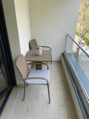 a balcony with a table and a chair on a balcony at Maya apartman sa dve spavace sobe in Vrnjačka Banja
