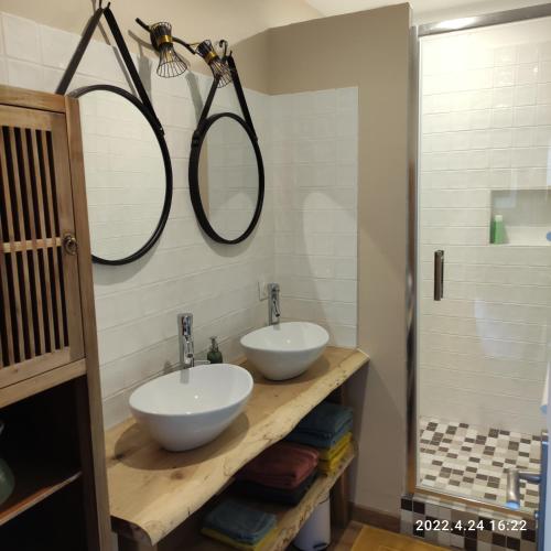 La salle de bains est pourvue de 2 lavabos et de 2 miroirs sur le mur. dans l'établissement LES MOUETTES DU PORT, à Honfleur