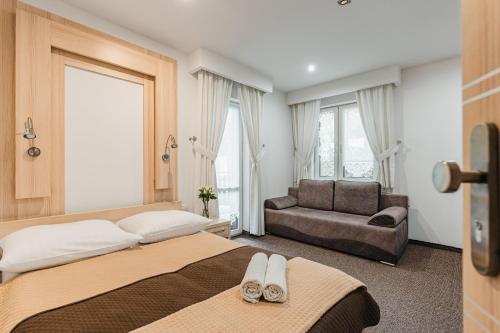 a hotel room with a bed and a couch at Willa Lala in Szczawnica