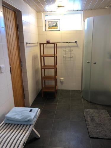 a bathroom with a shower and a bench in a room at Österlen - Skillinge in Skillinge