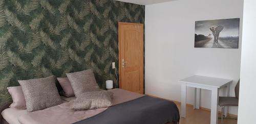 ein Schlafzimmer mit einem Bett mit einer grünen Wand in der Unterkunft Ferienwohnung Happy in Tangermünde