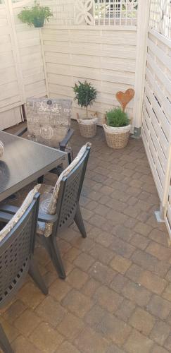 a patio with a table and chairs and potted plants at Ferienwohnung Happy in Tangermünde