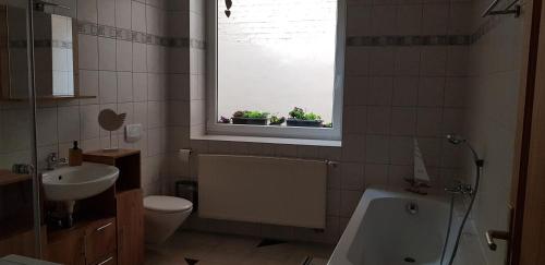 a bathroom with a sink and a toilet and a window at Ferienwohnung Happy in Tangermünde