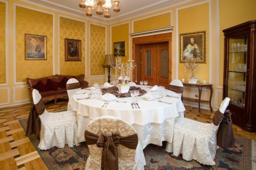 a dining room with a white table and chairs at Dwór Hetman in Jarosław