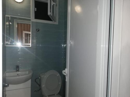 a small bathroom with a toilet and a sink at Blue summer villa in Sinemorets