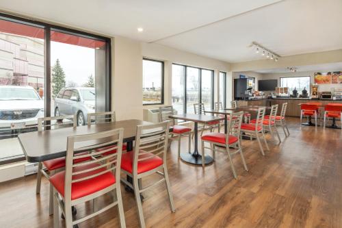 a dining room with tables and chairs and windows at Comfort Inn in Ottawa