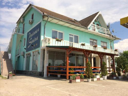 a blue building with a balcony on top of it at Pensiunea Simina in Caransebeş