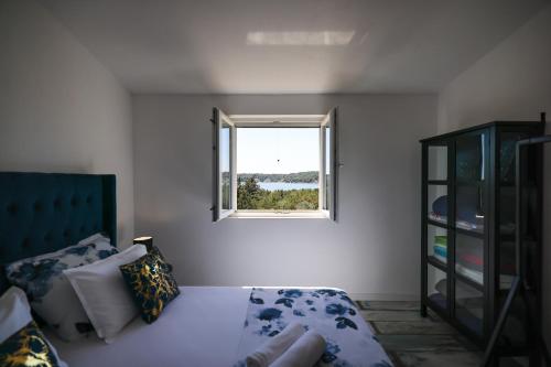 a bedroom with a bed and a window at Apartments Marta in Verunić