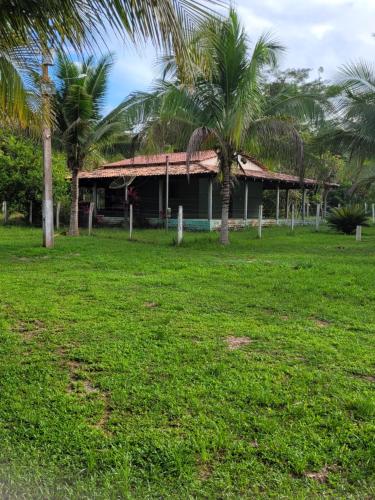 a house with palm trees in front of a yard at RECANTO DO SABIÁ in Carolina