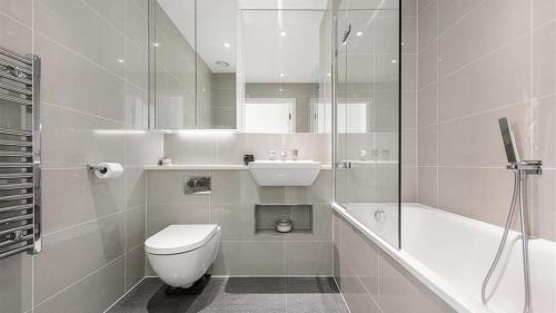 a bathroom with a toilet and a sink and a shower at 23 floor studio for work 1Gb WiFi in Croydon
