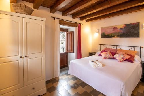 een slaapkamer met een wit bed en een raam bij Casa rural Can Rotes con jardin y barbacoa in Sant Joan de Labritja