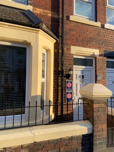 a brick building with a gate and a door at The Beaches - En-suite Rooms in Redcar
