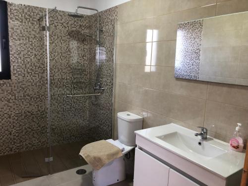 La salle de bains est pourvue d'une douche, de toilettes et d'un lavabo. dans l'établissement Calheta Ocean View Family Apartment, à Estreito da Calheta