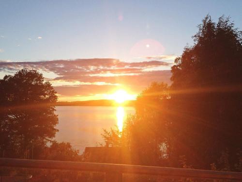 a sunset over a lake with the sun setting at 7 person holiday home in ALLINGSÅS, SVERIGE in Hjälmared