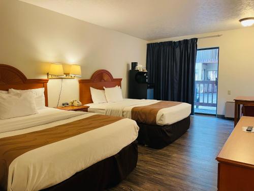 a hotel room with two beds and a balcony at America's Best Value Inn Sandpoint in Sandpoint