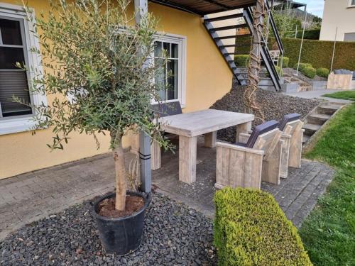 un tavolo con sedie e un albero in un cortile di Haus Elke a Blankenrath