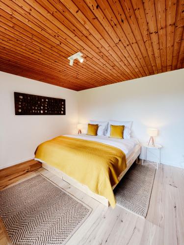 a bedroom with a large bed with a wooden ceiling at Ruhestifter-Salem mit Aromasauna und Hot Tub in Salem