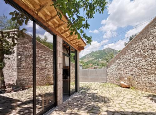 una vista esterna di una casa in pietra con porte in vetro di VILA RIRA - Rrajcë, Shebenik a Përrenjas