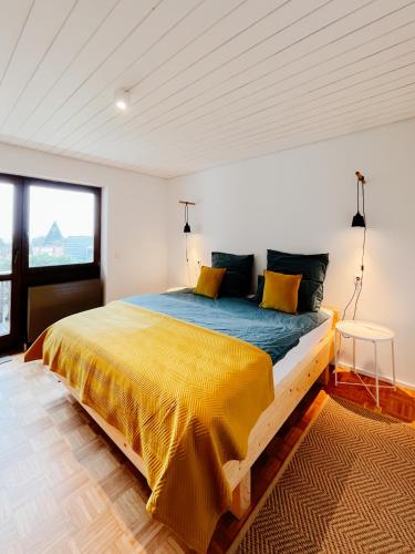 a bedroom with a large bed with a yellow blanket at Ruhestifter-Salem mit Aromasauna und Hot Tub in Salem