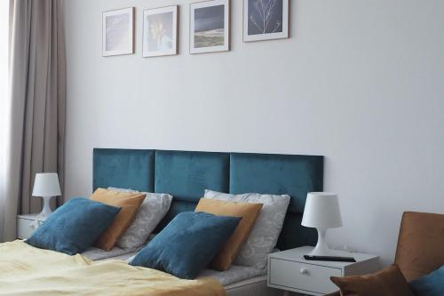 1 dormitorio con 1 cama con cabecero azul y almohadas en Apartament 303 Planeta, en Mielno