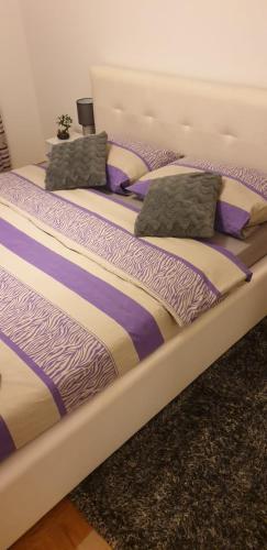 a bed with two pillows on top of it at Apartman Aura in Zagreb