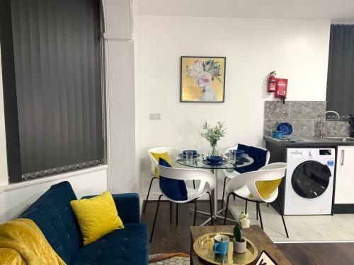 a living room with a blue couch and a table at Kunda House Moseley Apartments in Birmingham