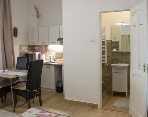 a kitchen and dining room with a table and chairs at Fabi Apart in Hévíz