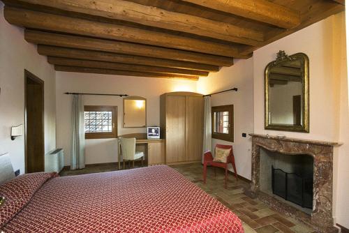 a bedroom with a large bed and a fireplace at Villa San Biagio in Mason Vicento