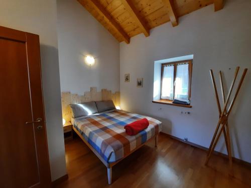 a bedroom with a bed in a room with a window at Maso Daü in Marter di Roncegno