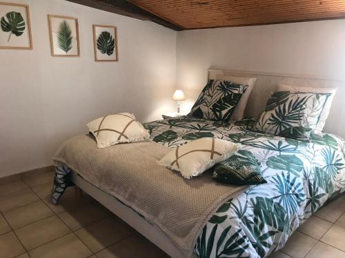 a bedroom with a bed with pillows on it at les gîtes de La Cossais in Saint-Cyr-en-Talmondais
