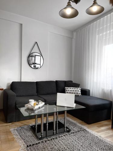 a living room with a couch and a table with a laptop at Pristina City Apartment in Pristina