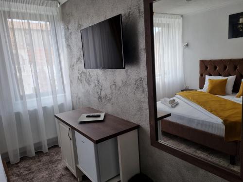 a bedroom with a bed and a mirror and a table at Vila Bun in Baile Felix