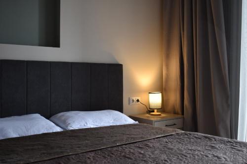 a bedroom with a bed and a lamp on a night stand at Apartment #102 in aparthotel in Tsaghkadzor