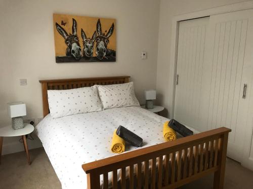 a bedroom with a bed with two objects on it at No 7 Quiet, two bedroom Ground Floor Flat in Tornagrain Great for early Airport departures or late flights in Dalcross