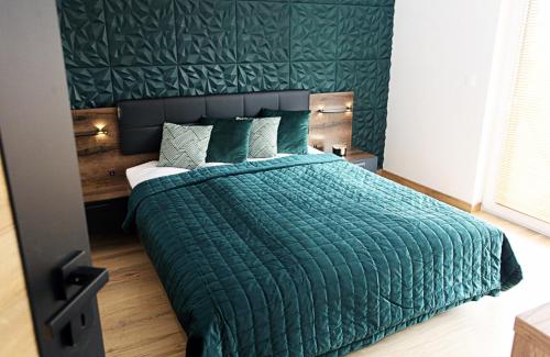 um quarto com uma cama verde e um edredão verde em Apartament Harmony em Olsztyn