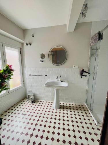 a white bathroom with a sink and a mirror at Casa Santa María 2 con jardín y barbacoa in Arévalo