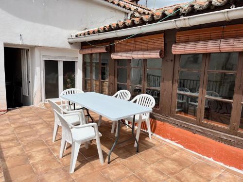 a white table and chairs on a patio at Casa Santa María 2 con jardín y barbacoa in Arévalo