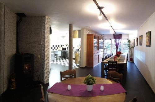 ein Esszimmer und eine Küche mit einem Tisch in einem Zimmer in der Unterkunft La Grange de David - Access-i in Hamoir