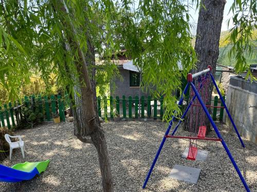 a playground with a swing set next to a tree at CHALET IL GELSOMINO DELL'ETNA in Giarre