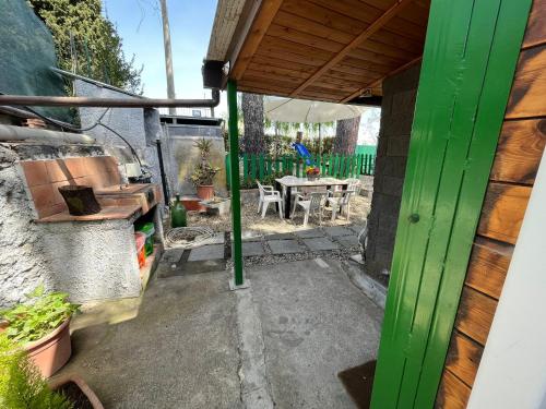 a patio with a green door and a table at CHALET IL GELSOMINO DELL'ETNA in Giarre