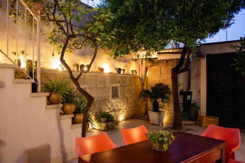 a patio with a wooden table and orange chairs at Amata Casa in Muro Leccese