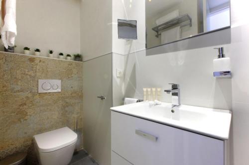 biała łazienka z toaletą i umywalką w obiekcie Precioso apartamento con vistas al mar y piscinas w mieście Benalmádena