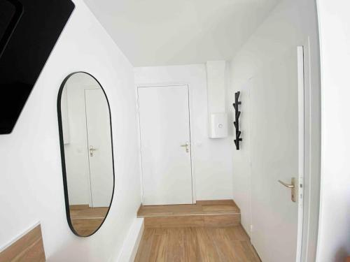 a mirror in a white room with a hallway at Studio design au centre de Reims in Reims
